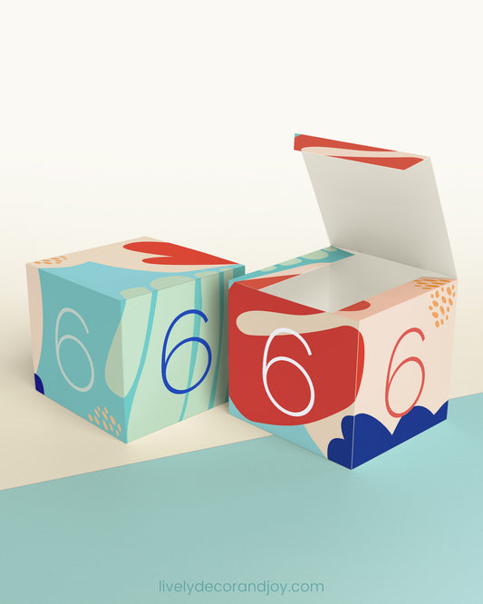 Two baby blocks with the same design and the digit 6 on the sides. One has the top lid open.