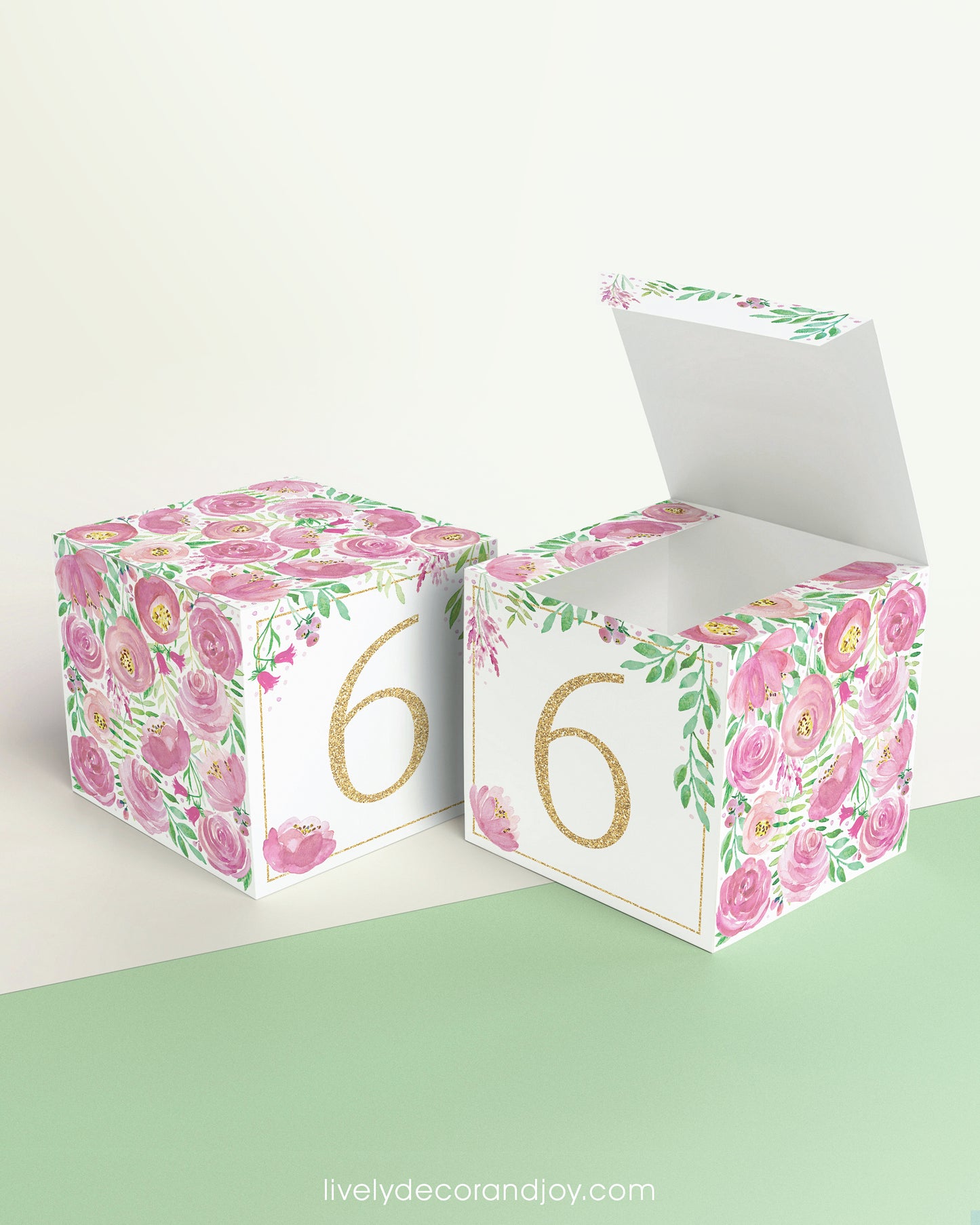Two paper cubes with pink floral designs and the digit 6 in gold. One has the top open, showing it can be a block or a box.