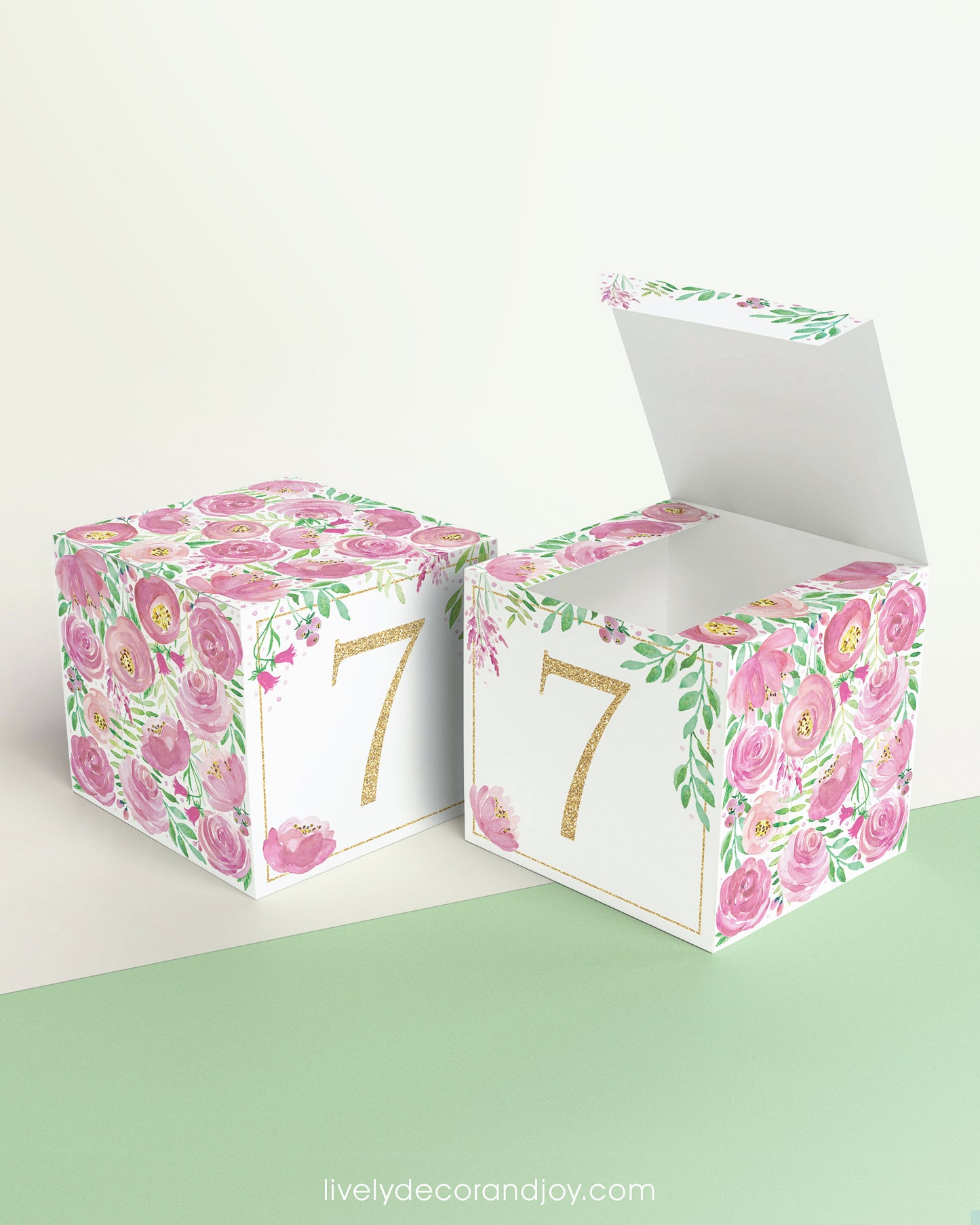 Two paper building blocks made with the same pink floral design and the number 7 in gold. One has the top lid open.