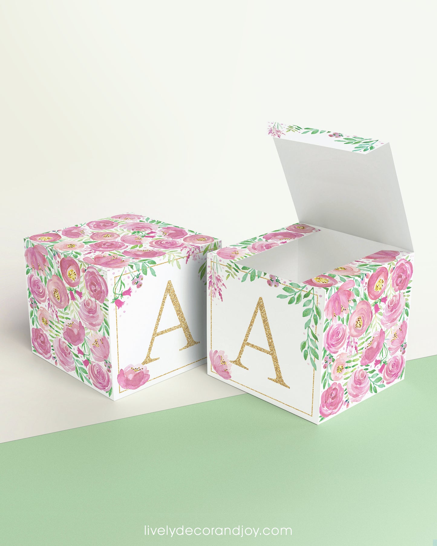 Two paper cubes with the same floral design and a capital A on the front. One has the lid open showing it can also be a box.