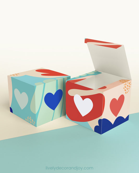 Two cubes with a heart on the sides. One has the lid open, showing it is a box. Both made with the same template.