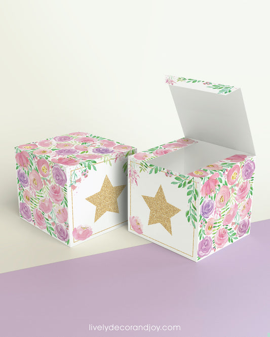 Paper building block with floral designs and a star on the front shown both as a cube and as an open box.