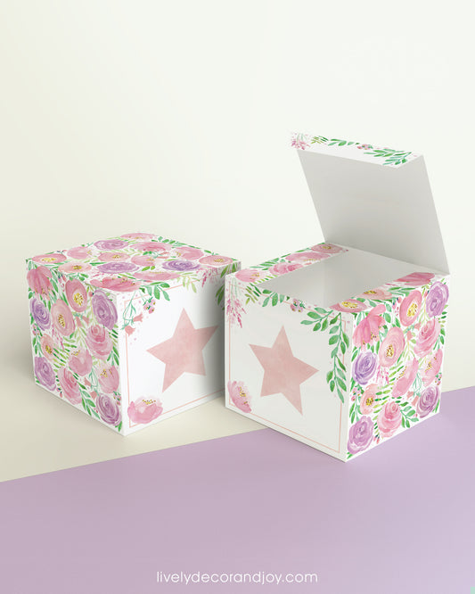 Paper building block with floral designs and a star on the front shown both as a cube and as an open box.