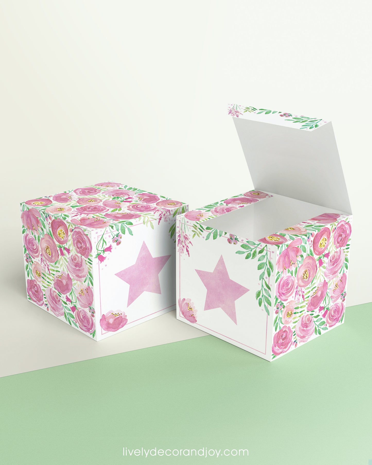 Paper building block with floral designs and a pink star on the front presented twice: as a cube and also as an open box.
