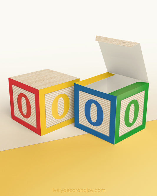 Paper building block in red, yellow, blue, and green. It has the number 0 on the sides and is on a wood table or shelf.