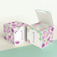 Paper cube shown as a closed block and also as an open box. It has purple floral designs and the number 1 in lavender.