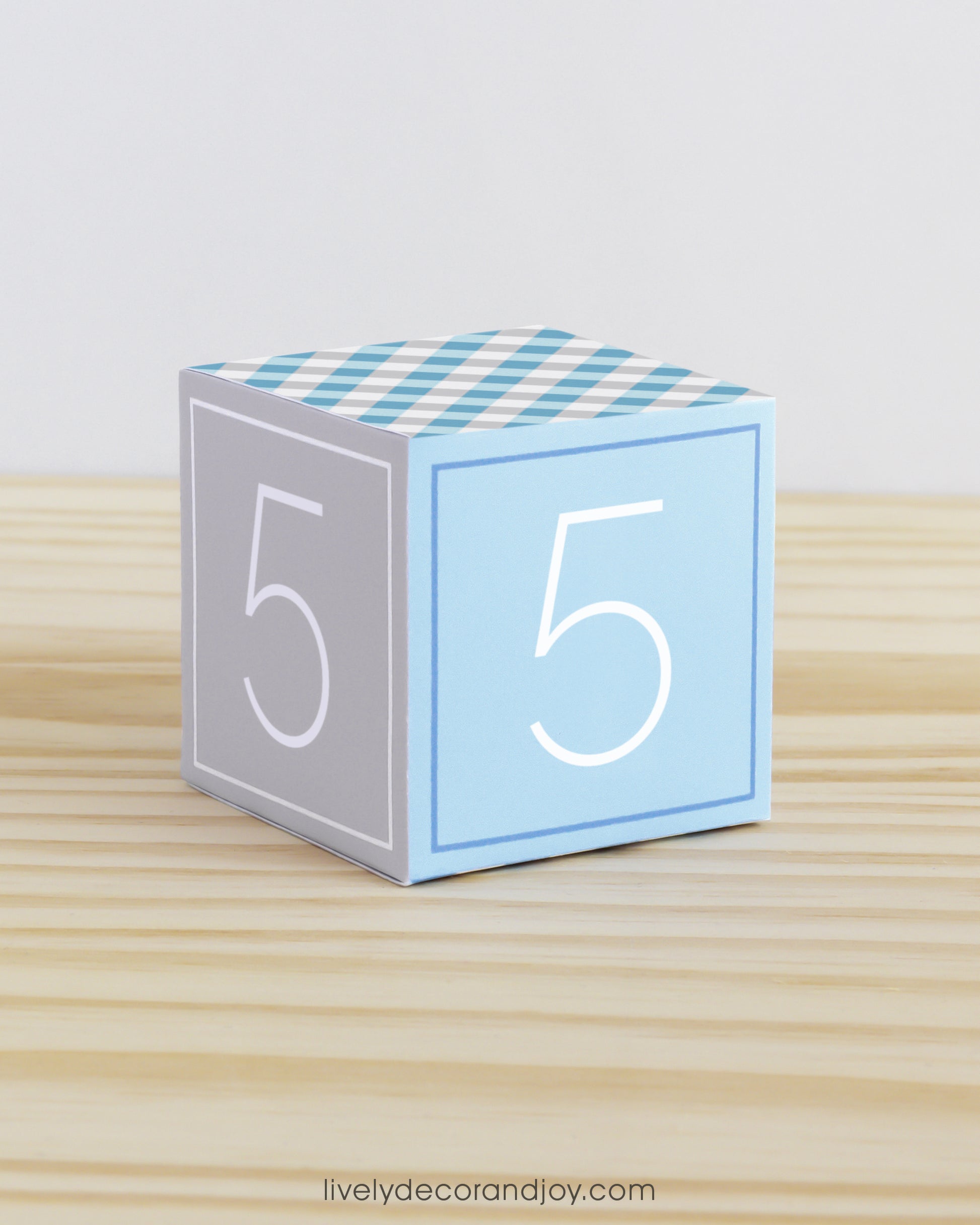 ABC block in blue and light grey with the number 5 on the sides. It is made of paper.