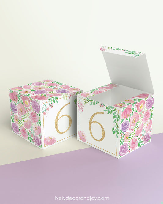 Two cubes with blush and lavender floral designs and the digit 6 in peach. One has the top open, showing it can be a box.
