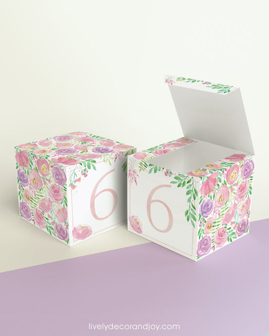 Two cubes with blush and lavender floral designs and the digit 6 in peach. One has the top open, showing it can be a box.