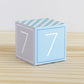 Paper cube in tints of blue and light grey and the number 7 on the sides. Made from a printable design.