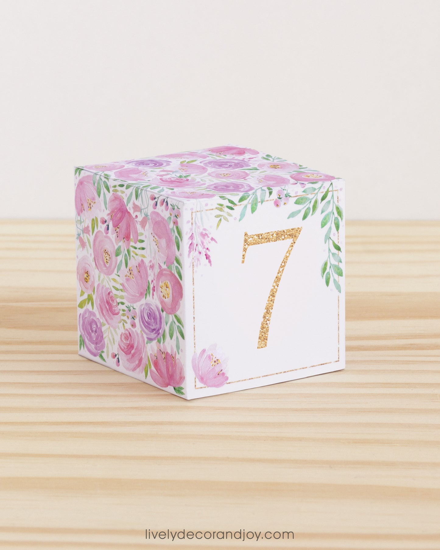 Paper cube with floral motifs in blush and lavender and the number 7 in peach on the front. Made from a printable design.