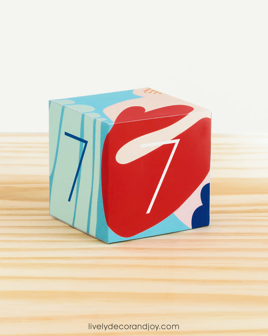 Modern paper cube in coral reef colors and the number 7 on the sides. Made from a printable design.