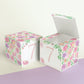 Two building blocks made with the same blush and lavender floral design and the number 7 in peach. One has the top lid open.