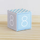 ABC block in blue and light grey with the number 8 on the sides. It is made of paper.