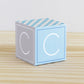 A paper cube in the modern wood block style with the letter C on the sides. The design is in blue and light grey.