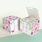 Two identical paper cubes with printed floral designs and the letter H. One has the top open, showing that it is a box.