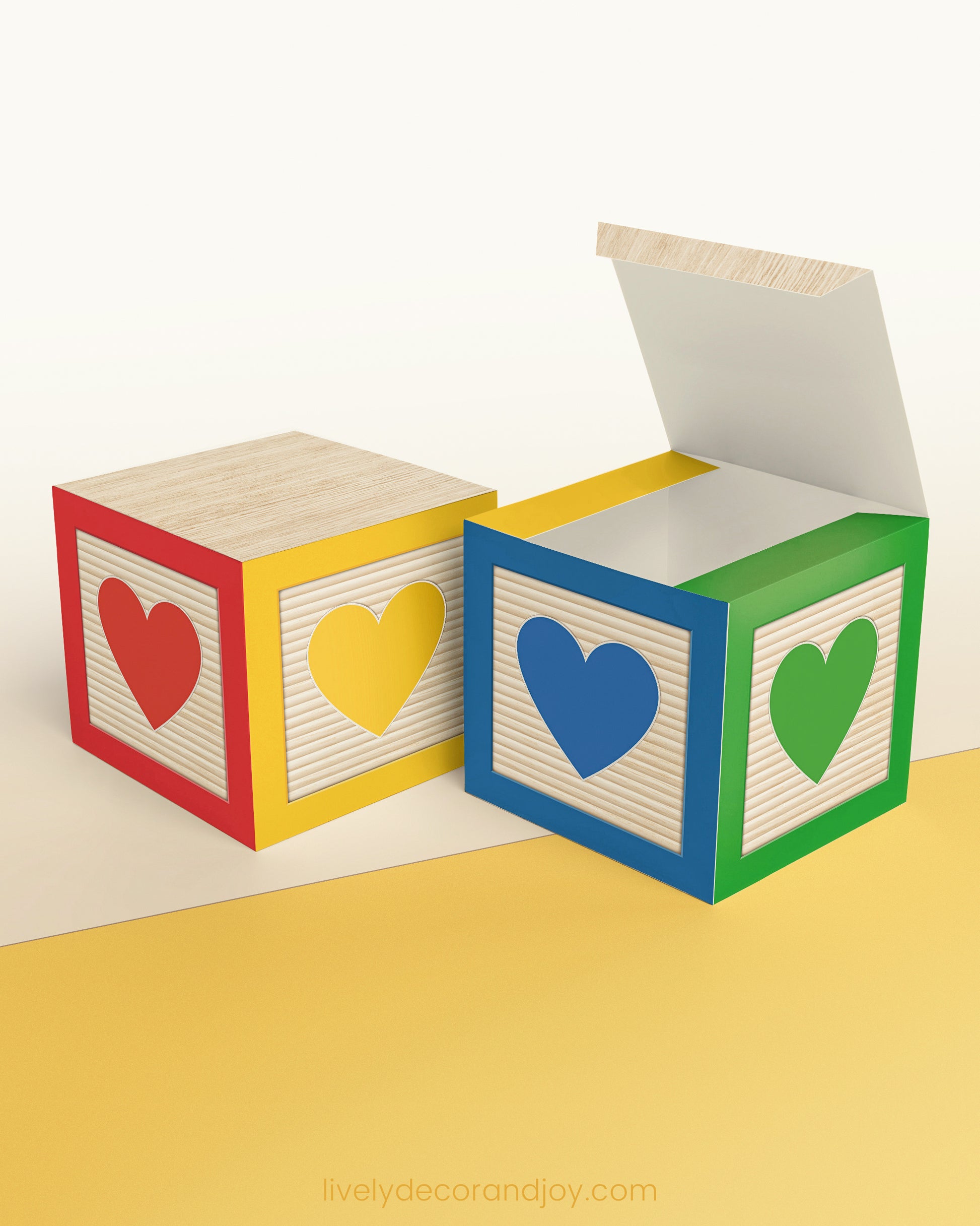 Paper alphabet cube with a heart on the sides. Designed in red, yellow, blue, and green. It is on a wooden table.