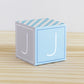 ABC block made of printed paper in tints of blue and light grey. Has the letter J on the sides.