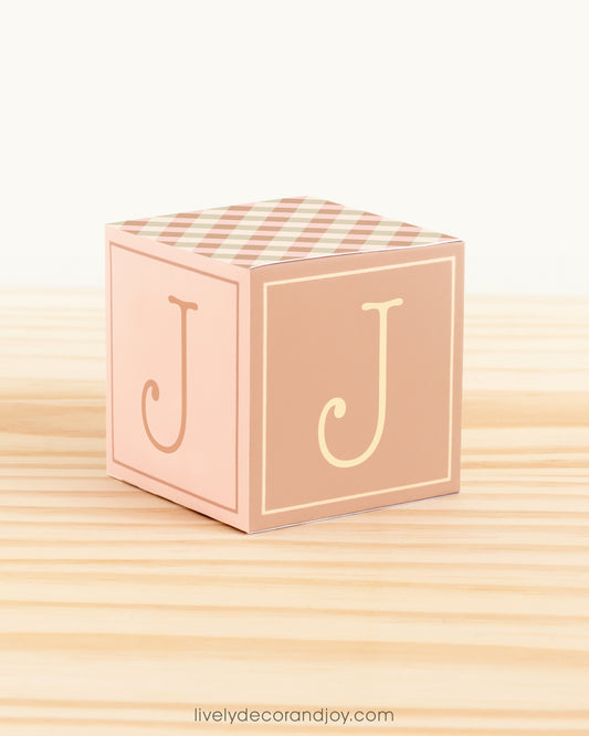ABC block made of printed paper in farmhouse colors. Has the letter J on the sides.