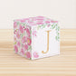 Block made of printed paper with watercolor flowers in pink tones and green leaves. Features a gold letter J on the front.