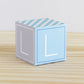 ABC block made of printed paper in tints of blue and light grey. Has the letter L on the sides.