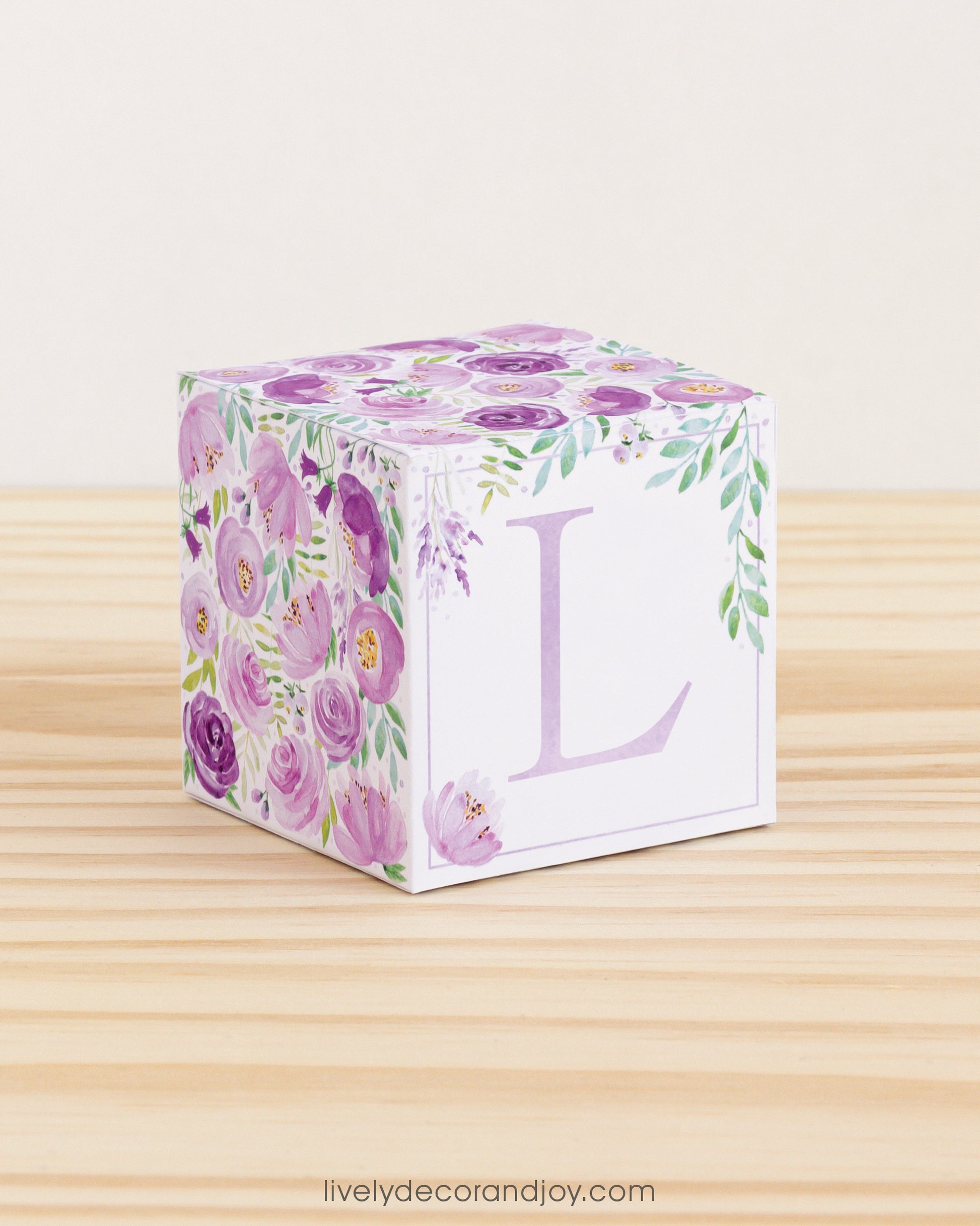 Cube with purple watercolor flowers and green leaves all around and the letter L in lavender.