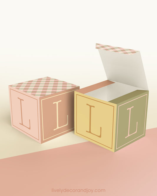 Two printed DIY paper cubes have the same designs, one of which has an open lid, showing that it is a box.