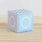 Baby block in tints of blue and light grey with the letter O. It is made of printed paper.