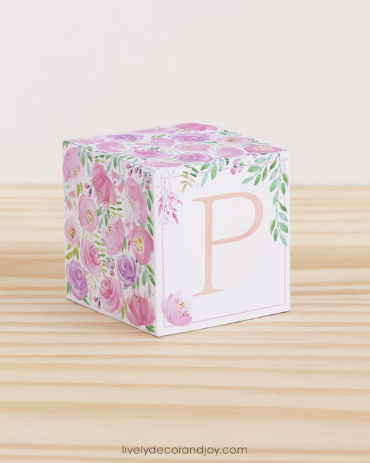 Paper building block features watercolor flowers in blush and lavender. A peach letter P is on the front.