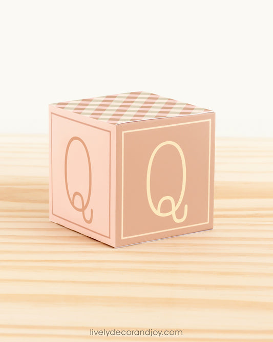 Letter block in cottagecore style with the letter Q on the sides. It is made of paper.