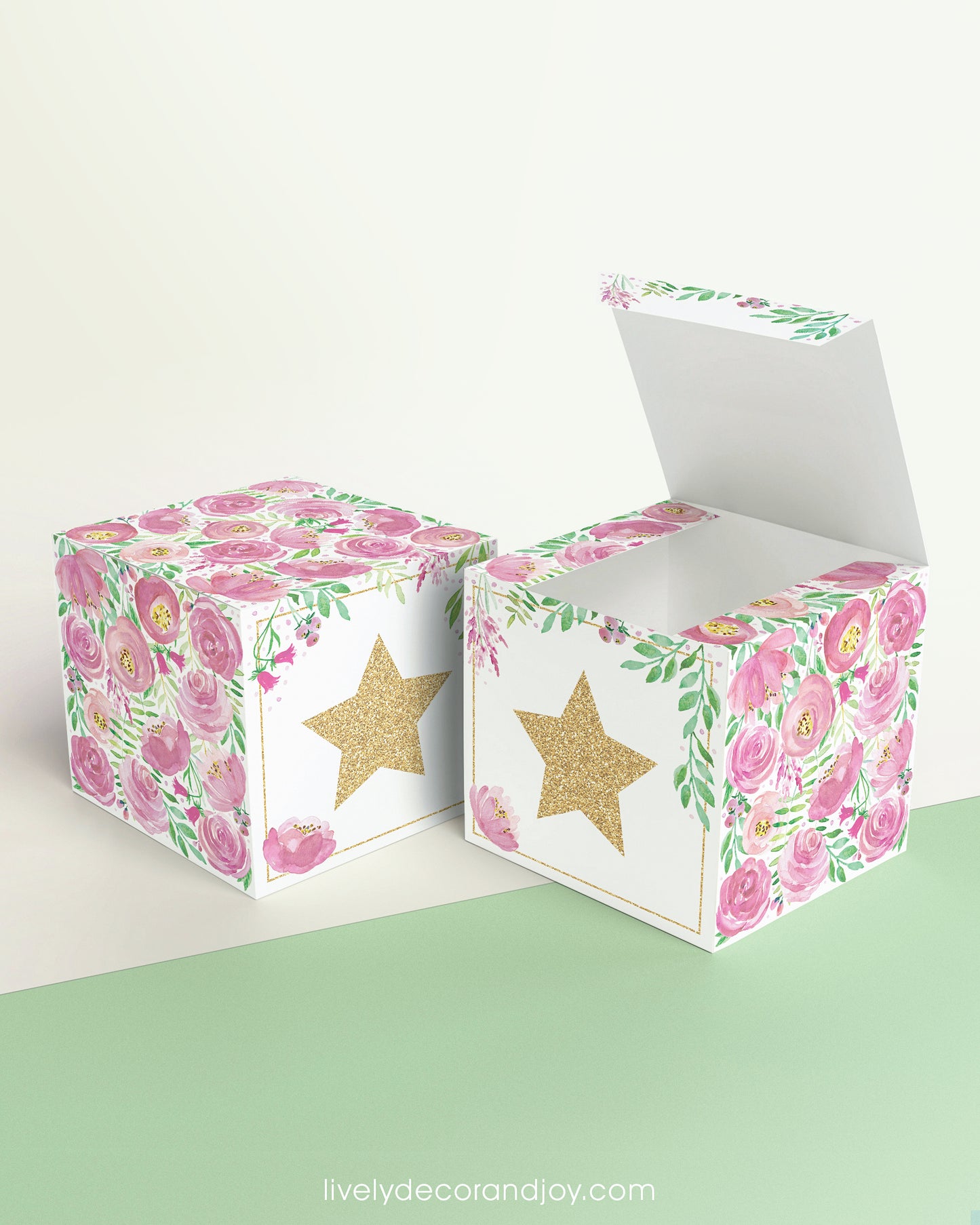 Paper building block with floral designs and a gold star on the front presented twice: as a cube and also as an open box.