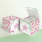 Paper building block with floral designs and a pink star on the front presented twice: as a cube and also as an open box.