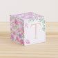 Block made of printed paper with watercolor flowers in blush and lavender. Features a peach letter T on the front.