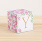 Building block made of printed paper with floral cottagecore designs and the letter Y on the front. It is on a wooden table.