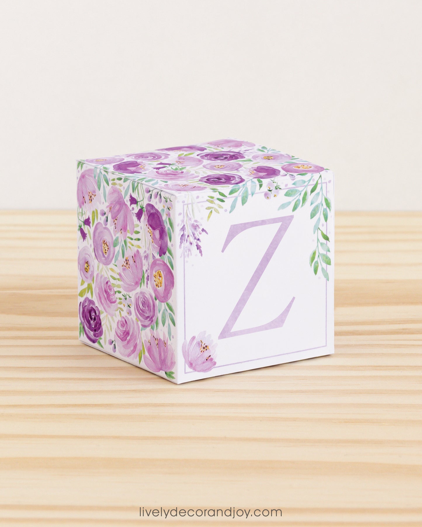 Block made of printed paper with watercolor flowers in purple tones and green leaves. Has a lavender letter Z on the front.