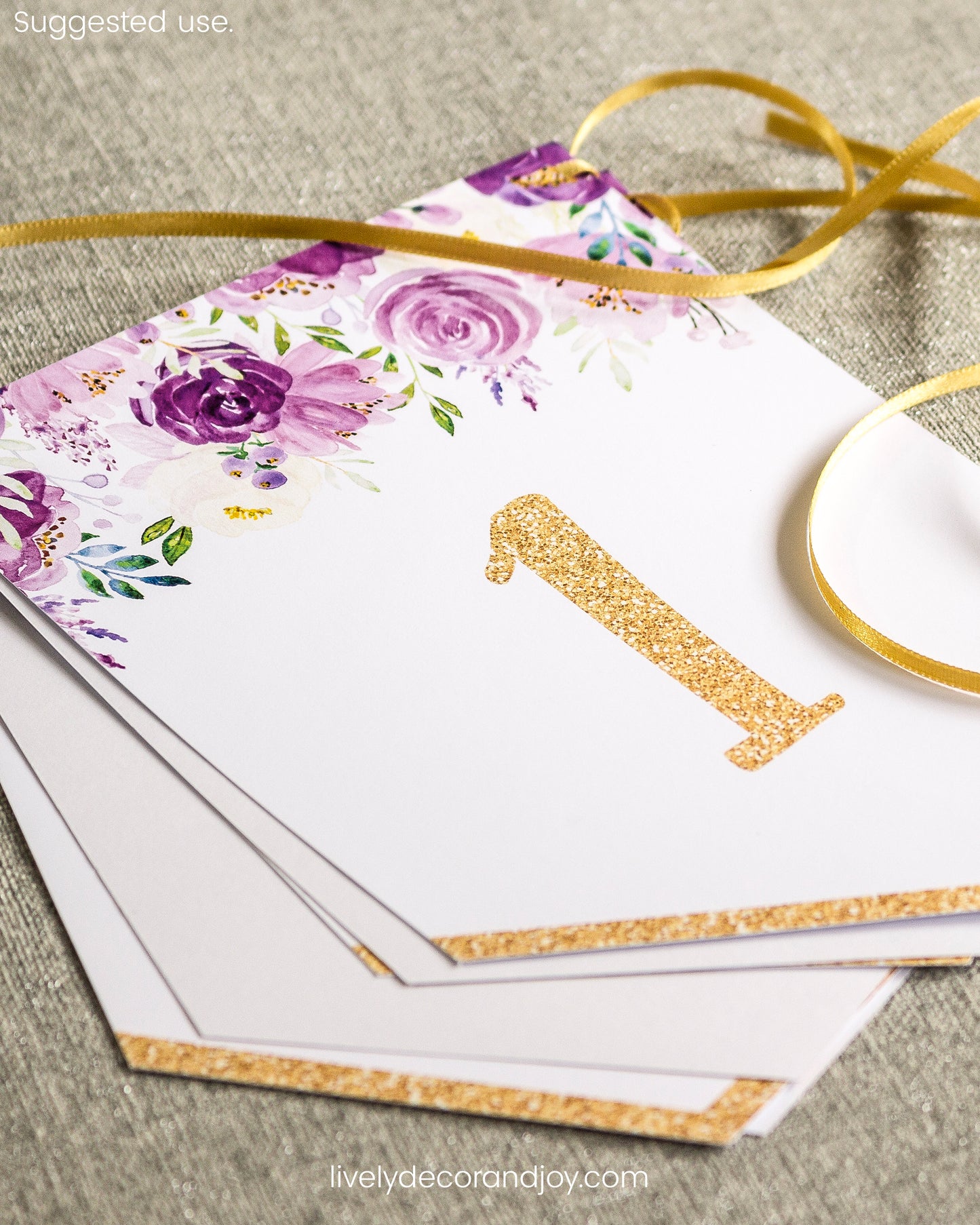 Purple floral flags on a table: a name banner printable set or an anniversary banner. Letters in gold.