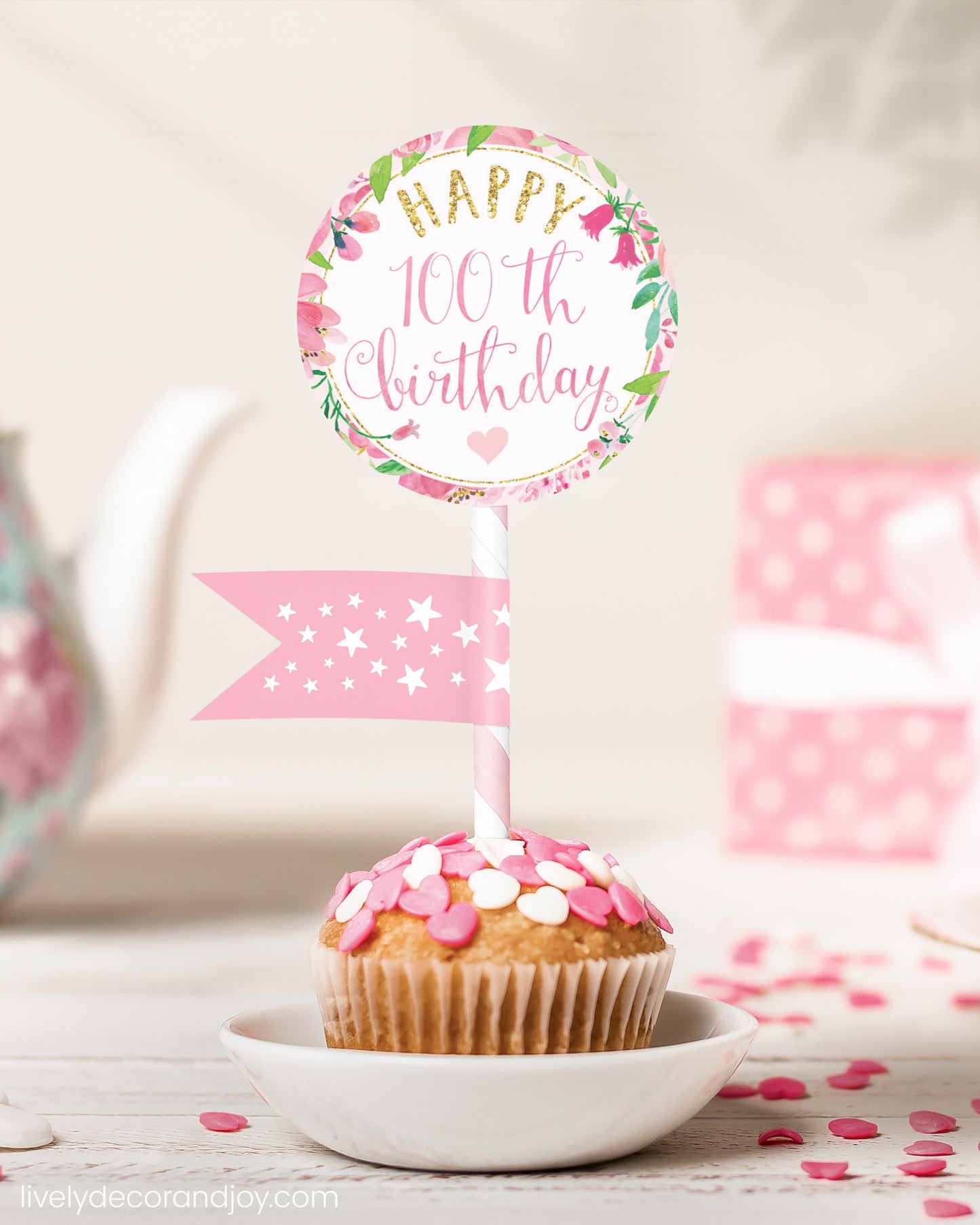 A cute 100th birthday cupcake or muffin topper with a mini flag on a tea-themed birthday party.