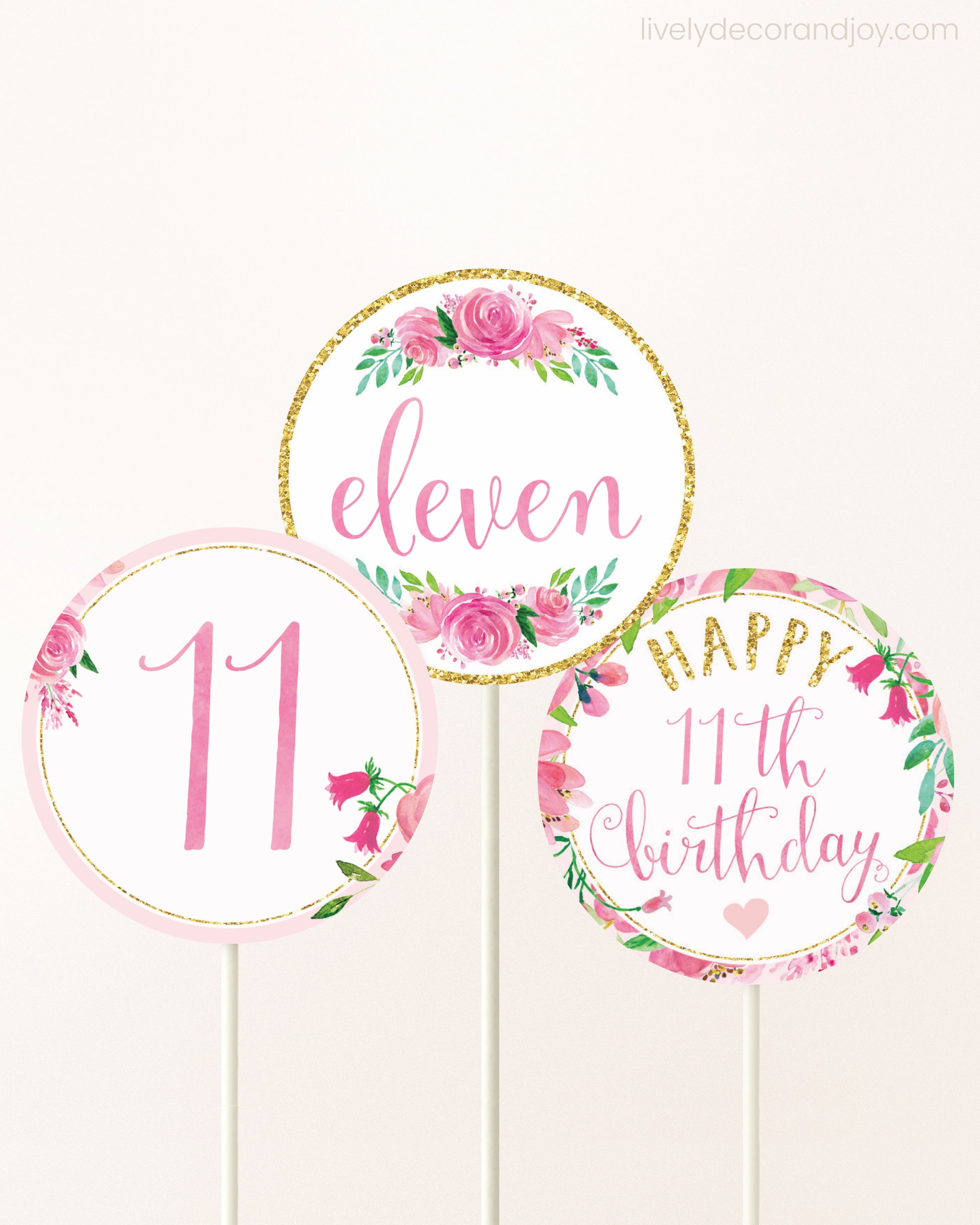 Three DIY toppers attached to lollipop sticks. They show printable cupcake topper designs with pink watercolor flowers.