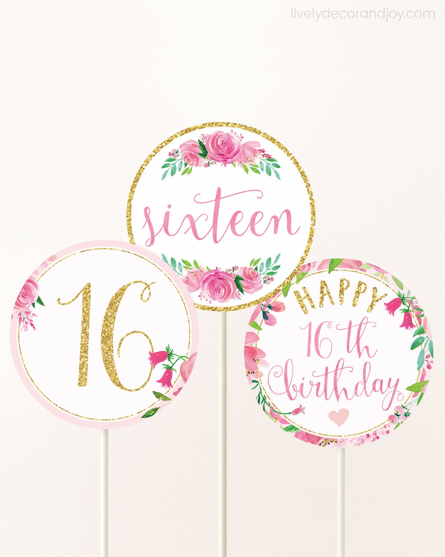 Three DIY toppers attached to lollipop sticks. They show printable cupcake topper designs with pink watercolor flowers.