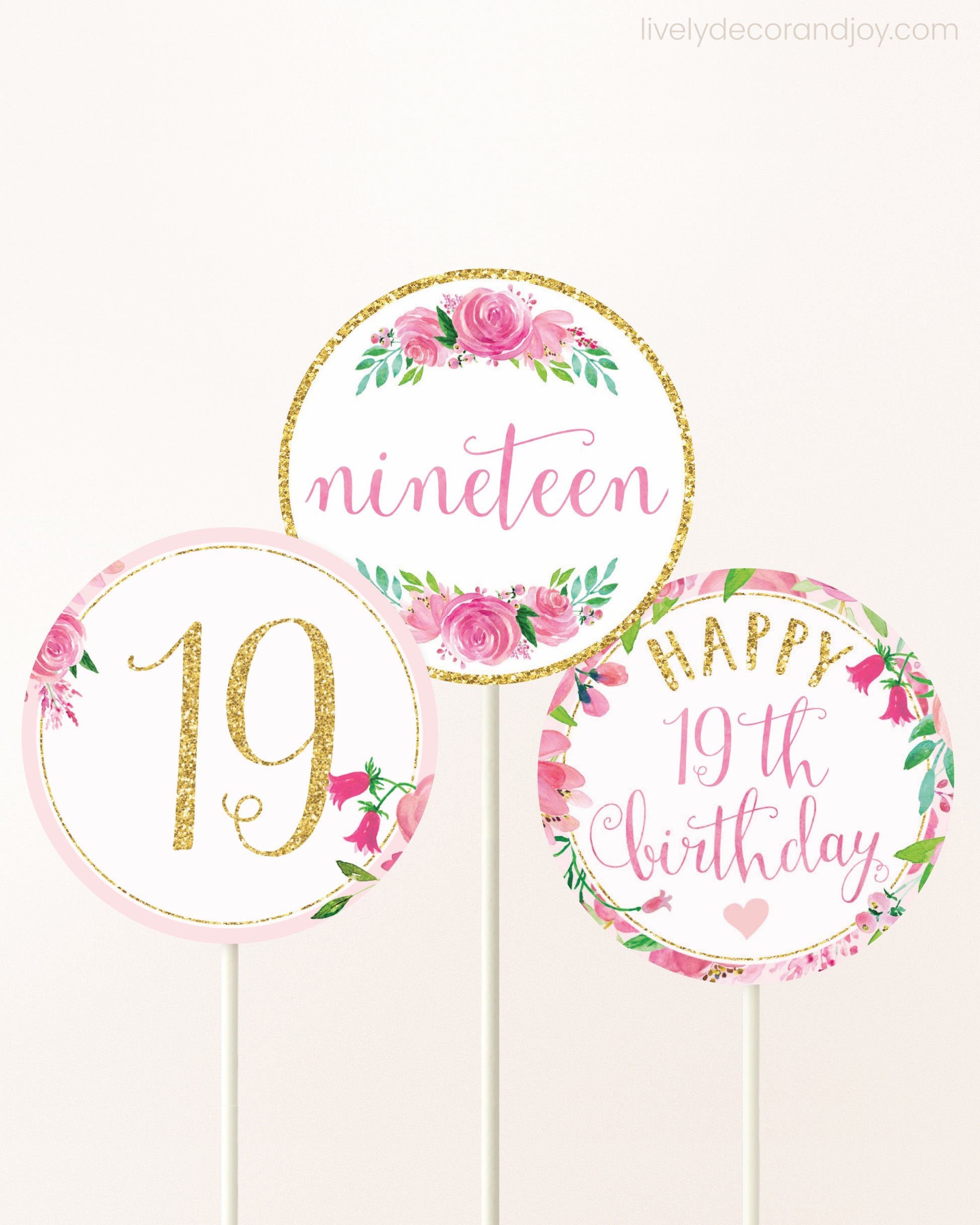 Three DIY toppers attached to lollipop sticks. They show printable cupcake topper designs with pink watercolor flowers.