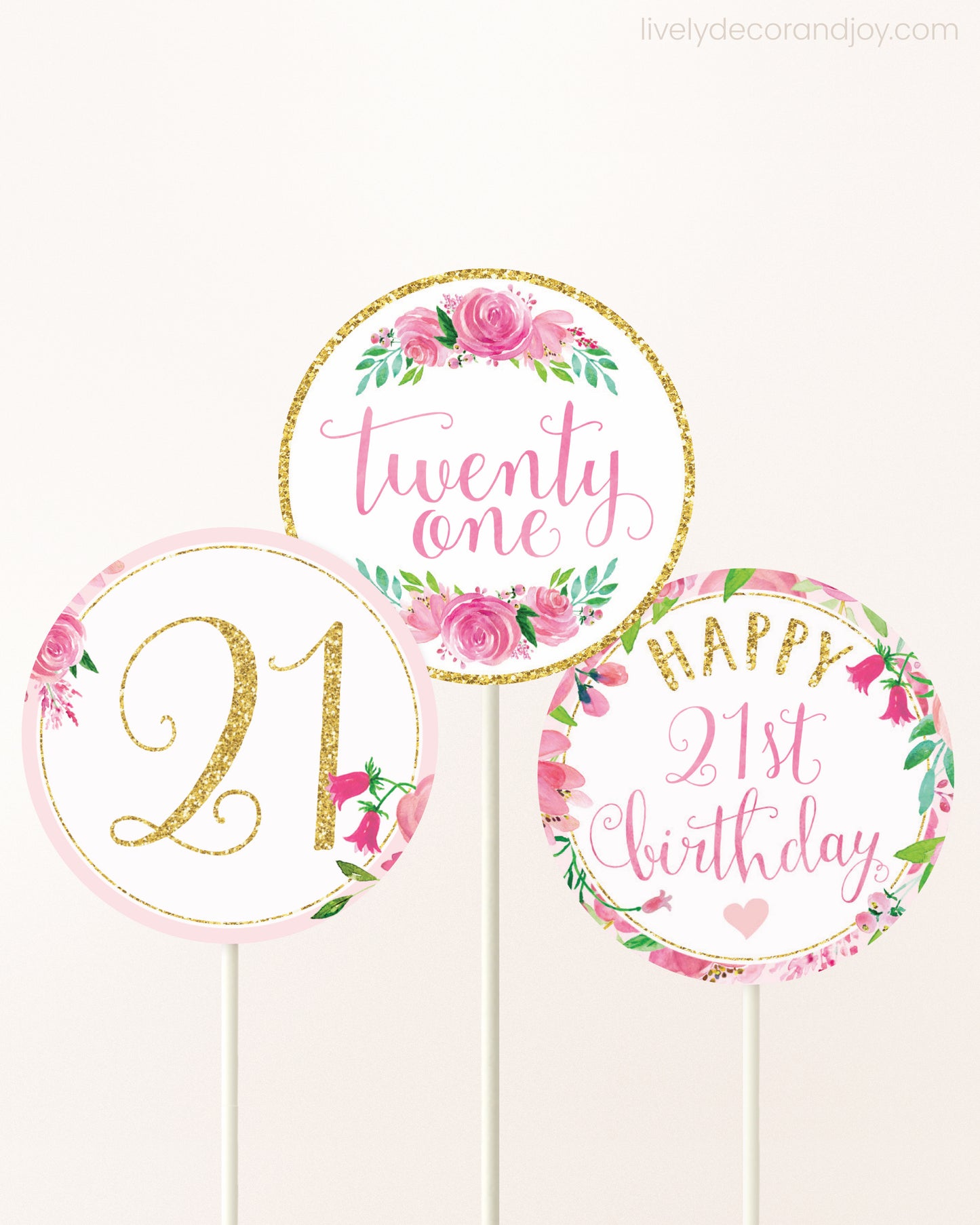 Three DIY toppers attached to lollipop sticks. They show printable cupcake topper designs with pink watercolor flowers.