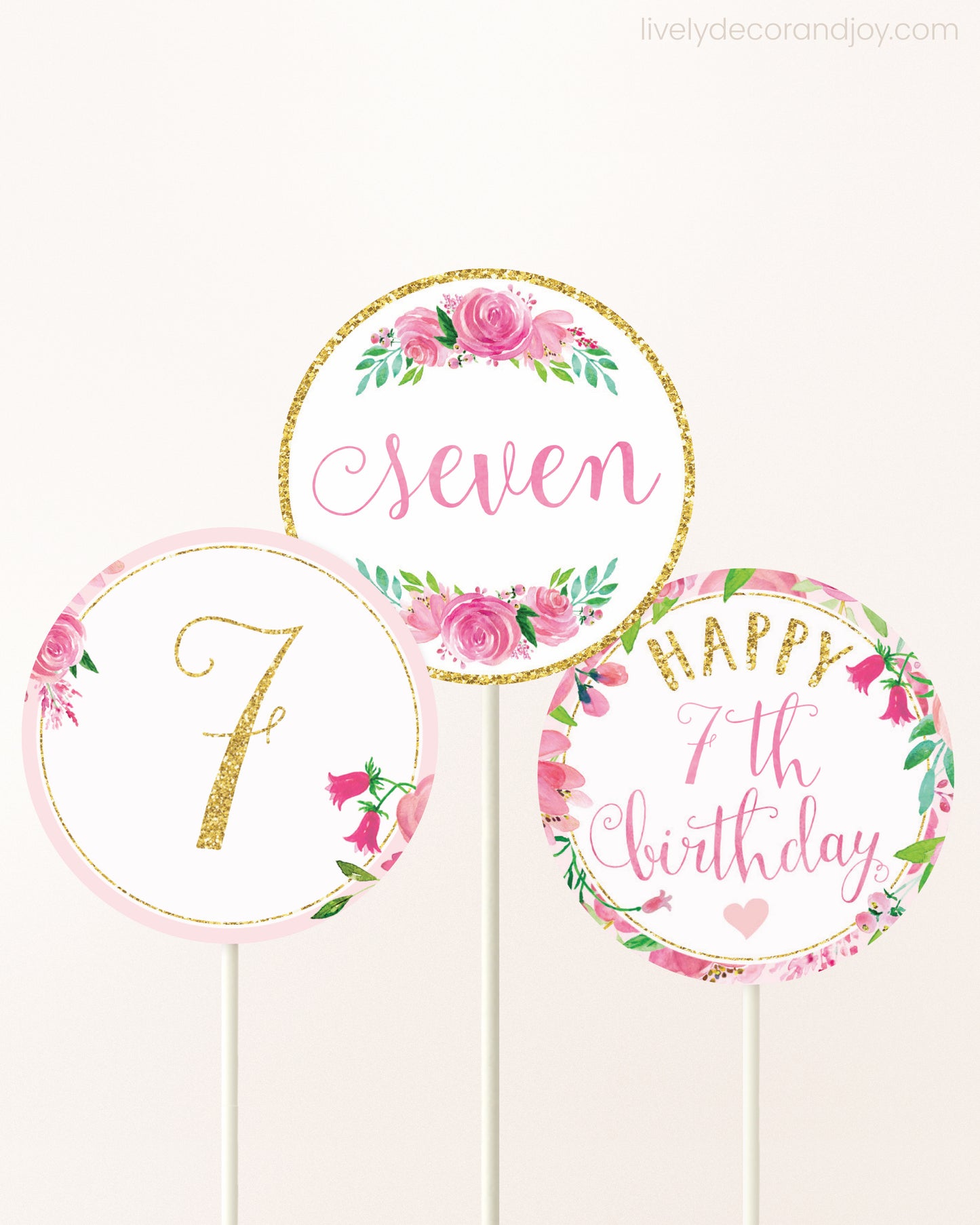 Three DIY toppers attached to lollipop sticks. They show printable cupcake topper designs with pink watercolor flowers.