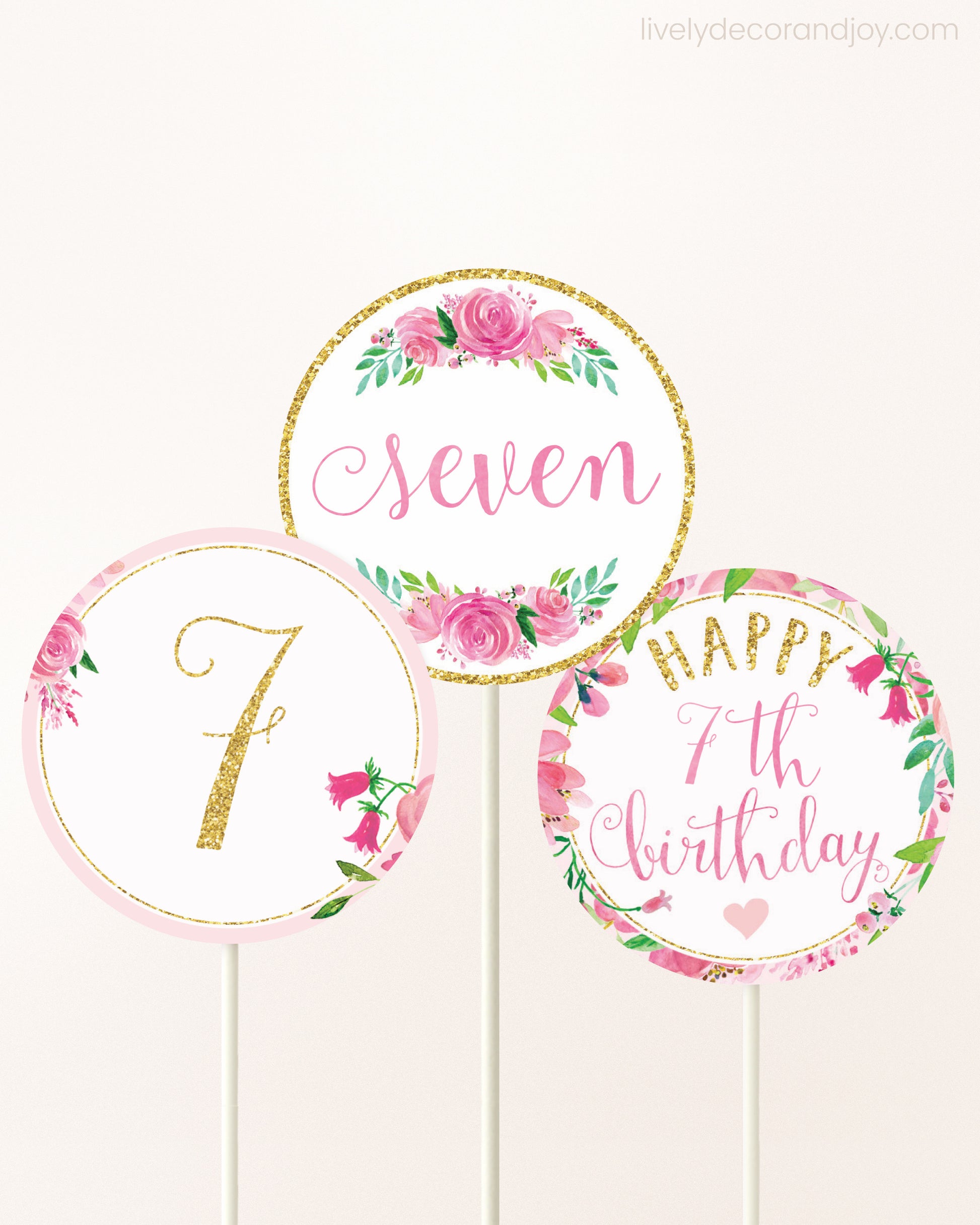 Three DIY toppers attached to lollipop sticks. They show printable cupcake topper designs with pink watercolor flowers.