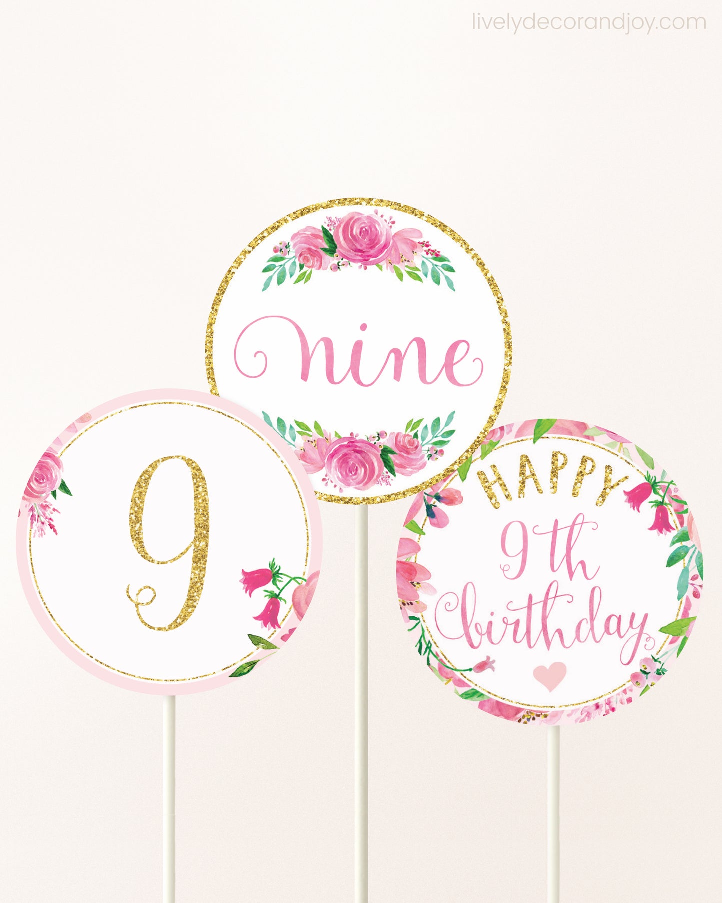 Three DIY toppers attached to lollipop sticks. They show printable cupcake topper designs with pink watercolor flowers.