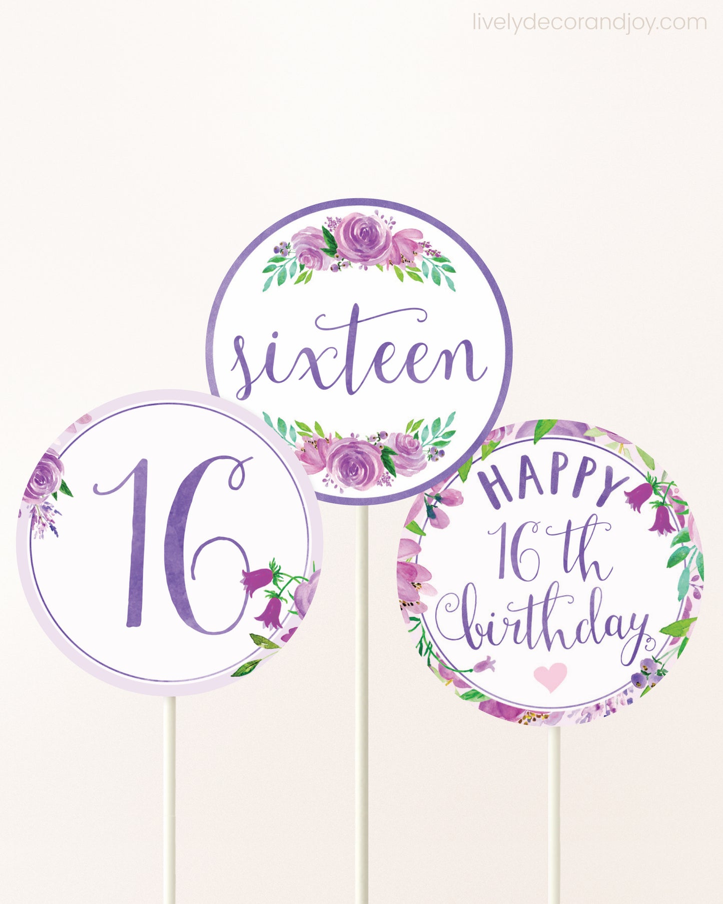 Three DIY toppers attached to lollipop sticks. They show printable cupcake topper designs with purple watercolor flowers.