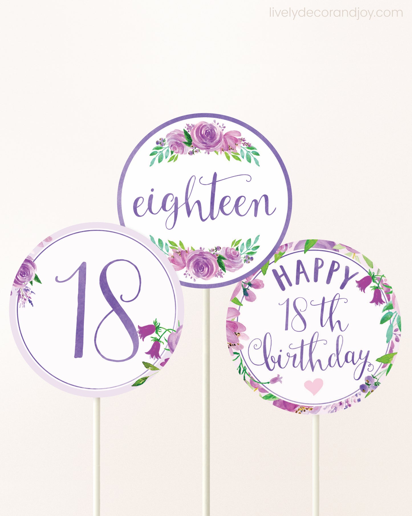 Three DIY toppers attached to lollipop sticks. They show printable cupcake topper designs with purple watercolor flowers.