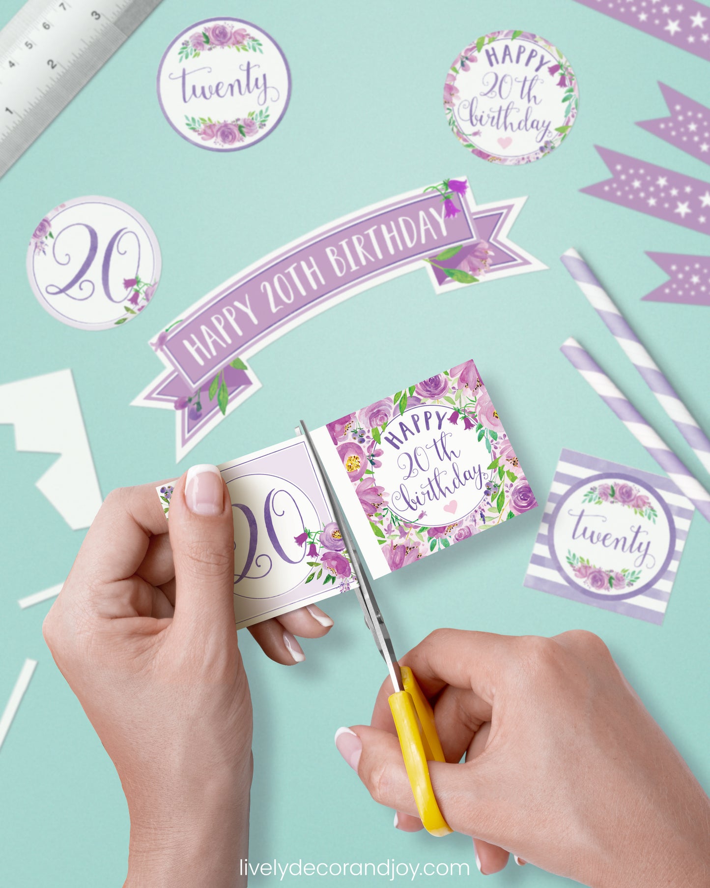 A woman cut a couple of square birthday tags after cutting round party labels, straw flags, and a cake topper.