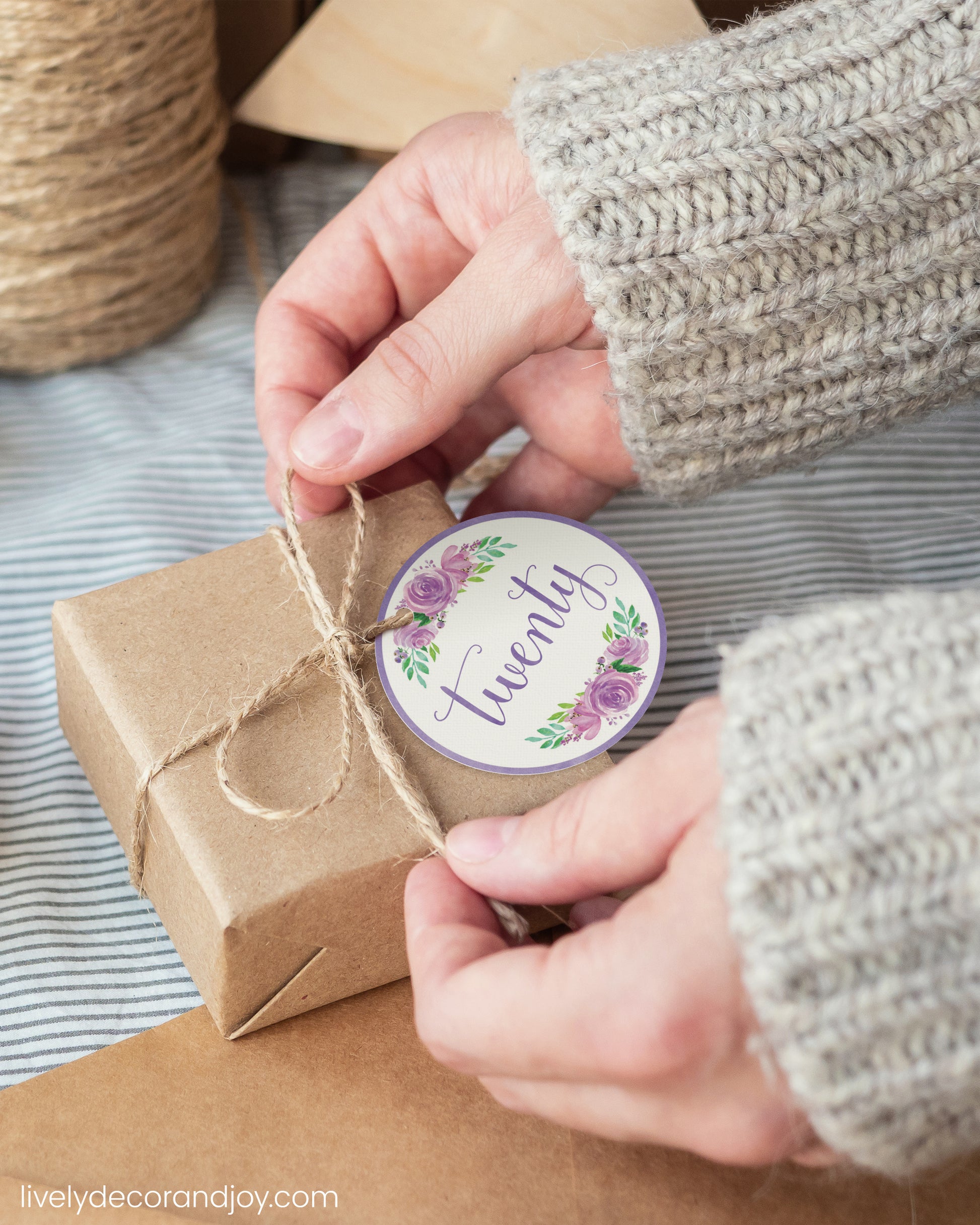A woman wrap a minimalist gift with a purple watercolor printable gift tag. Hygge or japandi atmosphere.