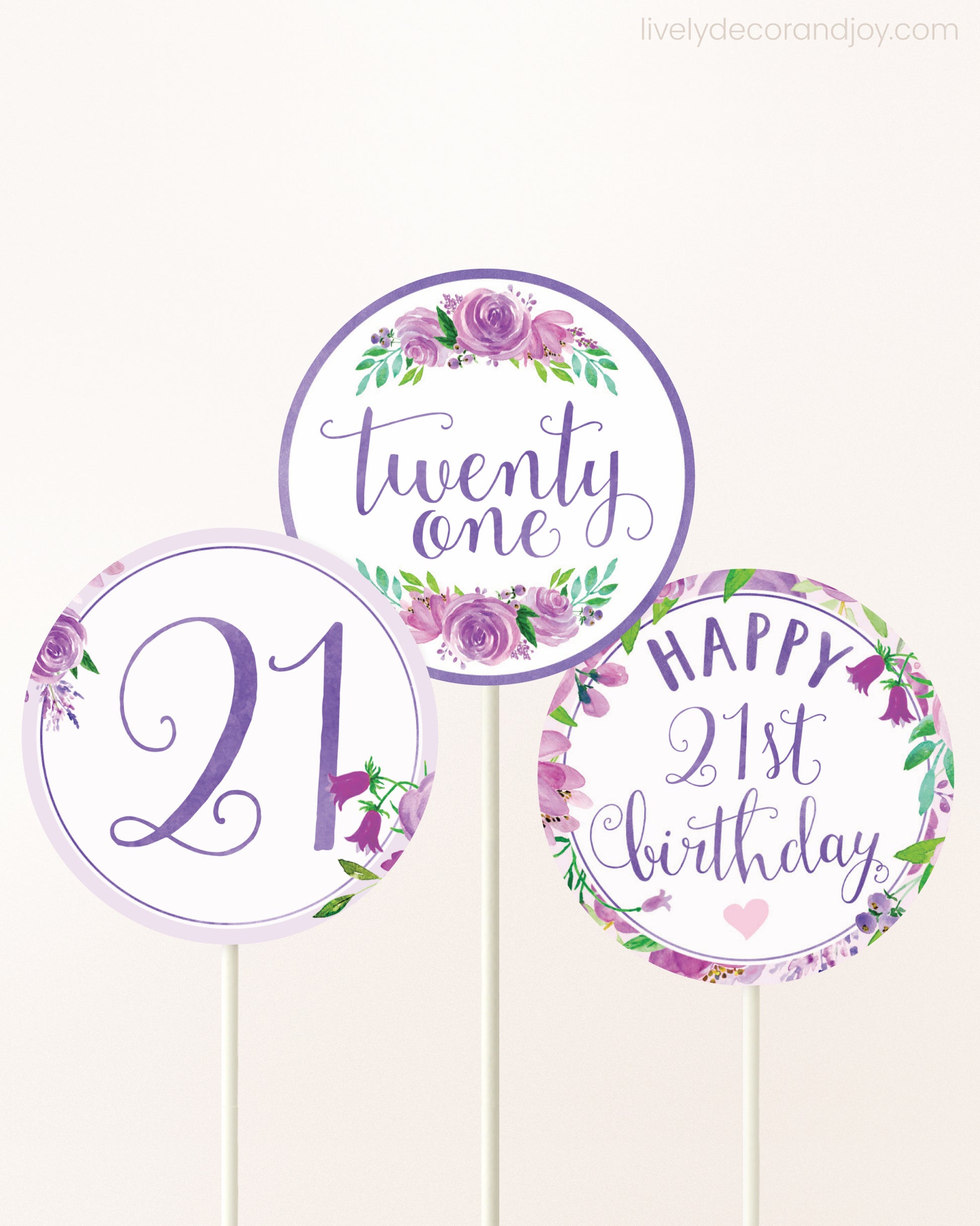 Three DIY toppers attached to lollipop sticks. They show printable cupcake topper designs with purple watercolor flowers.