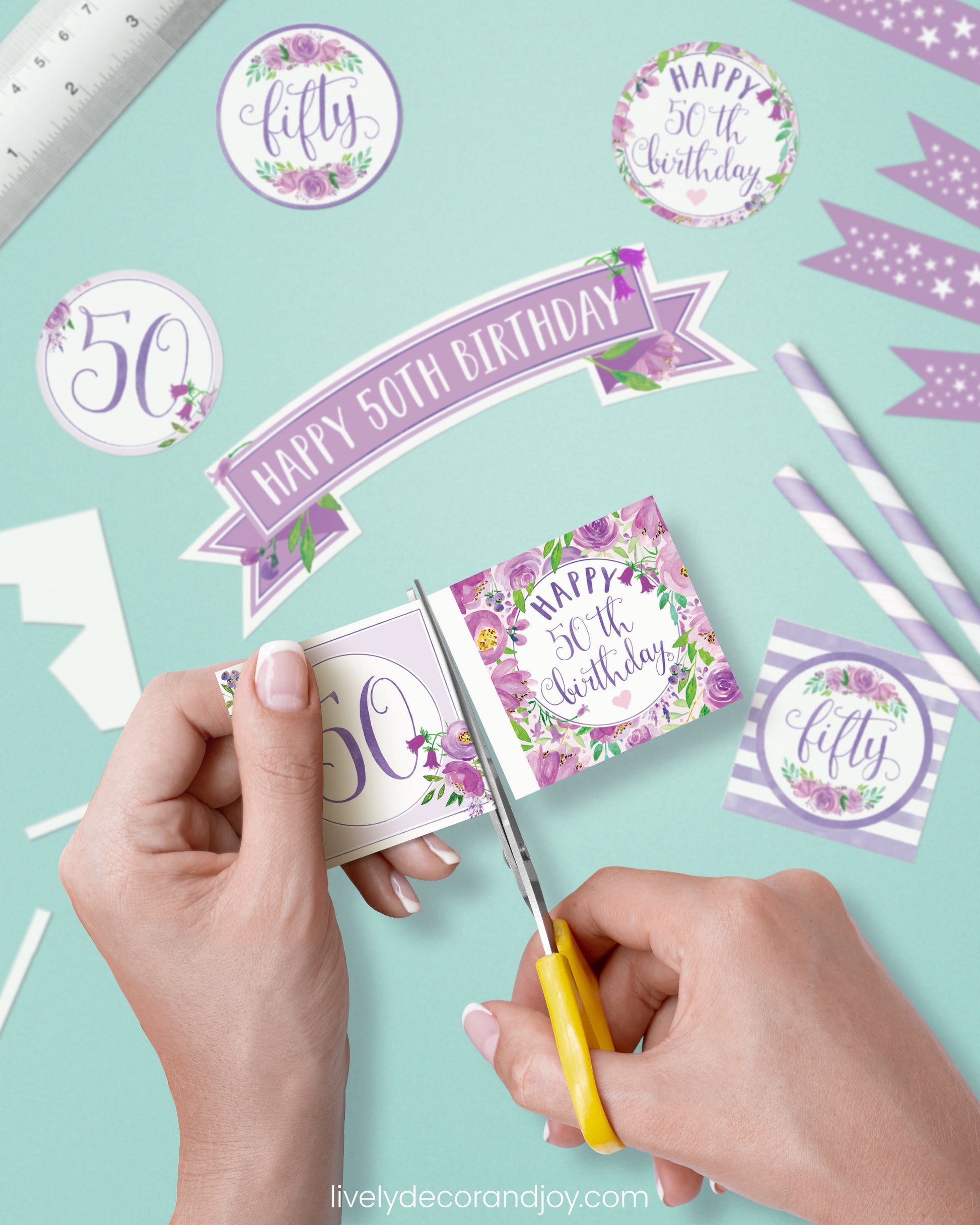 A woman cut a couple of square birthday tags after cutting round party labels, mini flags, and a cake topper.